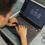 Profissional usa um laptop com software de inteligência artificial na tela durante o trabalho.