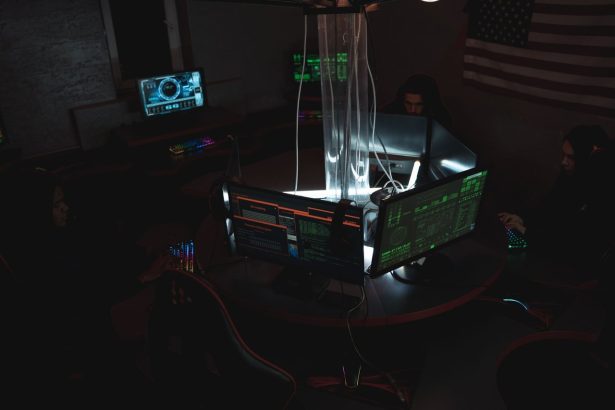 Equipe de profissionais trabalha diante de computadores em uma sala escura, em atividade relacionada à segurança cibernética