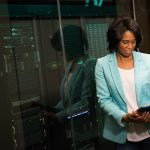 Profissional de tecnologia examina servidores em um moderno data center.