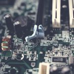 Close de componentes e circuitos de uma placa-mãe de computador.